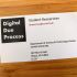 A photo of a business card for student researchers at the Digital Due Process Clinic, showing the clinic logo and contact data